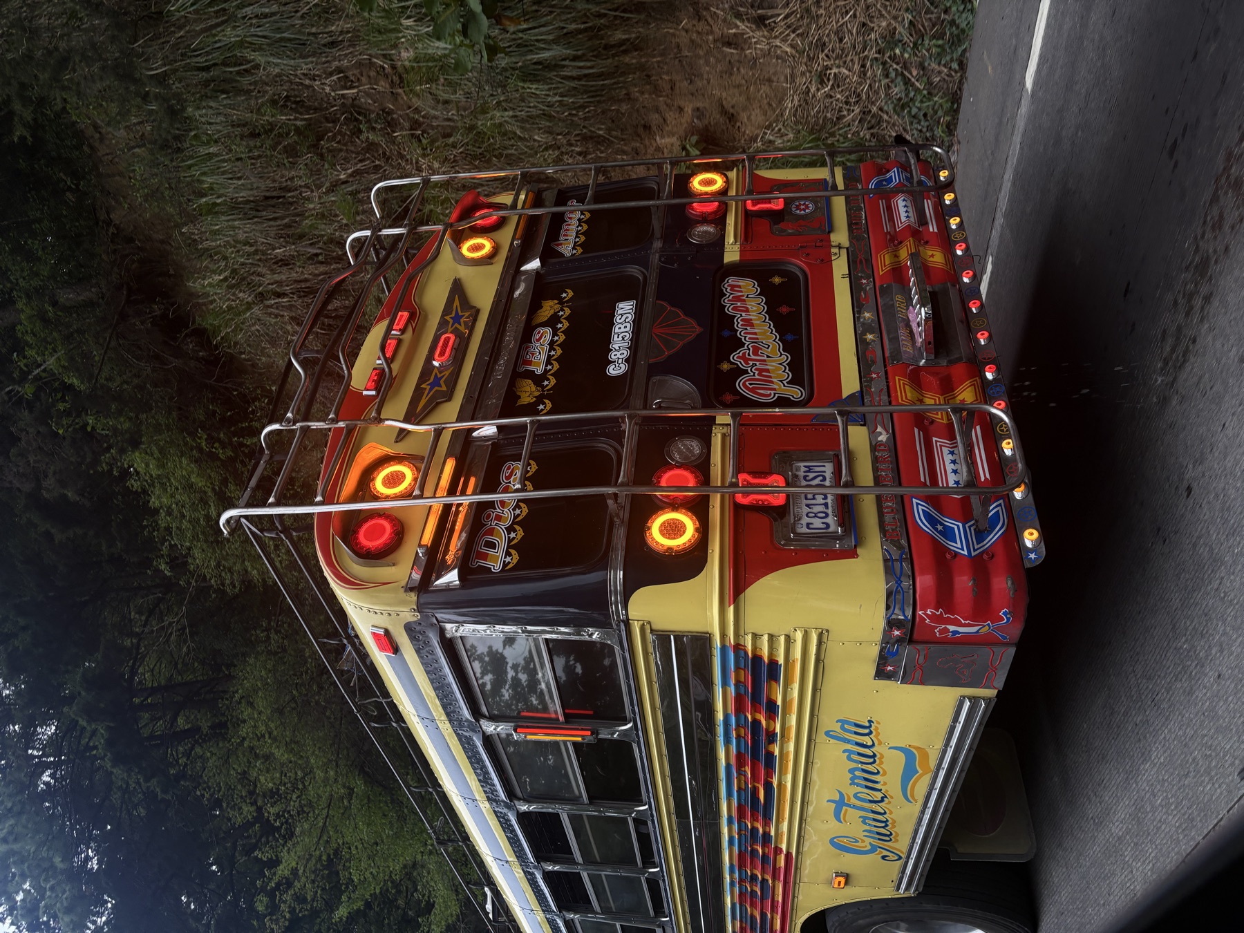 Rear of a red and yellow chicken bus on a Guatemalan mountain road
