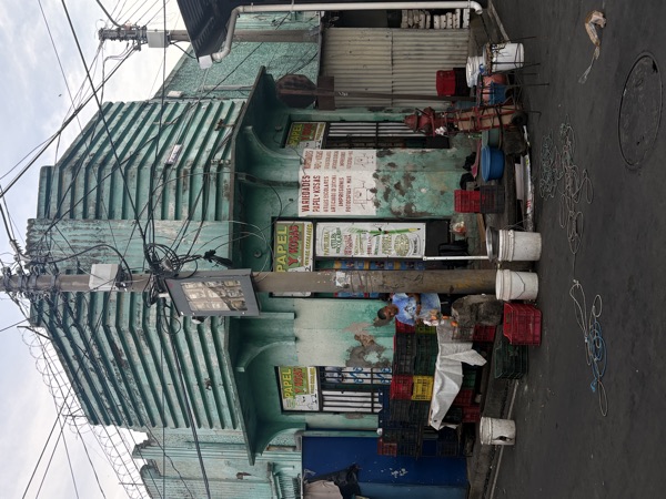 Green corner shop with people outside