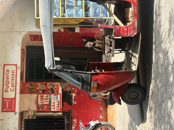 Red tuk-tuk outside Pulperia Carmen